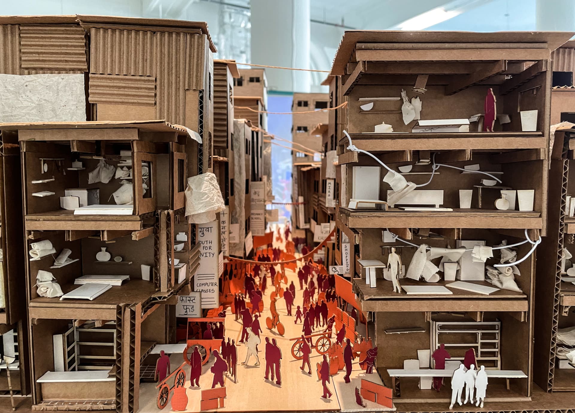 Cardboard sectional model of a dense market street with cut-out figures
